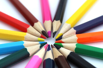 Fototapeta premium Bright multi-colored pencils lie on a white isolated background.