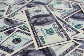 Texture from American one hundred dollar bills scattered on a flat surface.