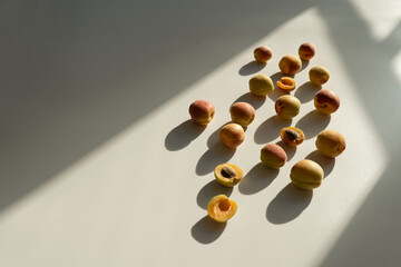 Obraz na płótnie Canvas Aesthetic fruit background. Ripe juicy peaches on white background with sunlight shadows. Fresh organic fruit vegan food