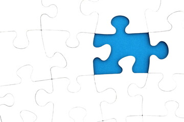 Fototapeta premium The game, a lot of white puzzle pieces lie on a blue background.