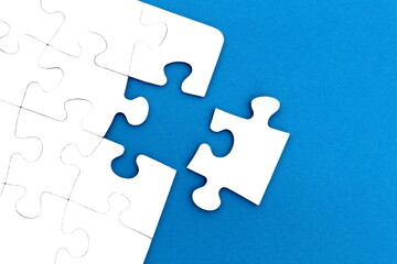 The game, a lot of white puzzle pieces lie on a blue background