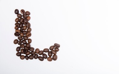 L is a capital letter of the English alphabet made up of natural roasted coffee beans that lie on a white background.