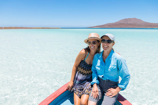 Two smiling women posing for picture on boat in Pacific Ocean, Coronado Island, Baja California Sur, Mexico