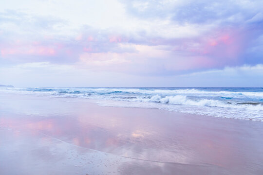 Beach and ocean landscape with pink sky, Sunrise Beach, Queensland, Australia