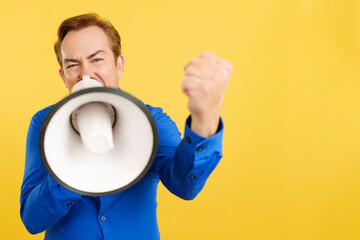 Angry mature man shouting using a loudspeaker