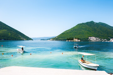 Fototapeta na wymiar Tourist boats at the bay pier of Perast town. Kotor bay, Montenegro