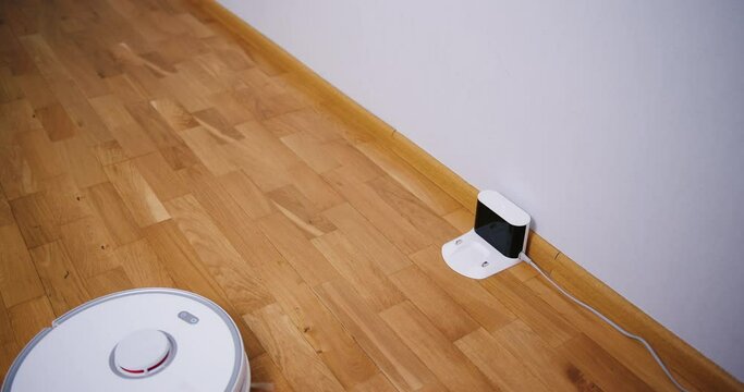 Robot vacuum cleaner performs automatic cleaning of the house at a certain time. Smart home concept. Copy space