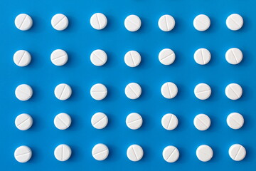 Abstract background of white pills on a blue background.