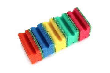 Many bright multi-colored sponges for washing dishes lie on a white background.