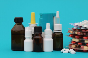 Different bottles of medicines stand on a turquoise background.