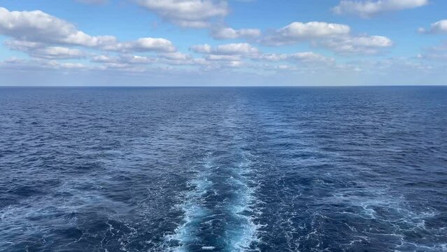 Cruise ship wake or trail on ocean surface. a wide footprint from the boat. ocean water. view from the back of the ship.
