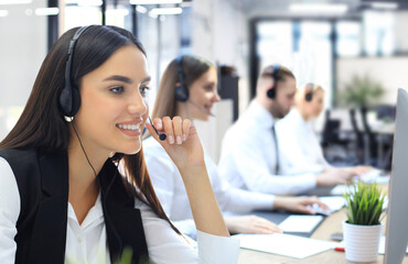 Portrait of call center worker accompanied by his team. Smiling customer support operator at work.