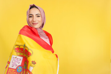 Happy muslim woman wrapping with spanish national flag