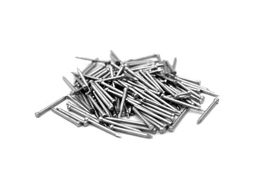 A pile of large iron nails lie on a white background.