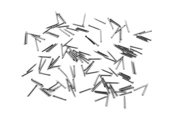 A pile of large iron nails lie on a white background	
