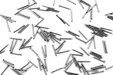 A pile of large iron nails lie on a white background
