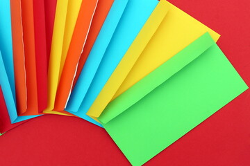 On a bright background lie bright multi-colored envelopes
