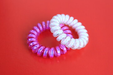 A bright hair band lies on a red background