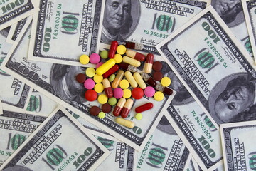 Capsule pills lie on the dollar money.