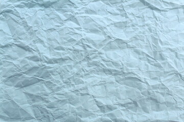 Soft crumpled sheet of light-colored paper. Abstract texture.