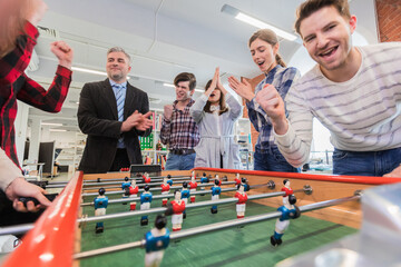 Employees playing table soccer - 575555092