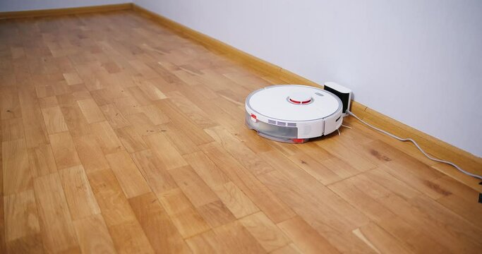 Robot vacuum cleaner performs automatic cleaning of the house at a certain time. Smart home concept. Copy space