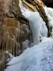 Fototapeta na wymiar frozen waterfall waters and icicles inside the cave