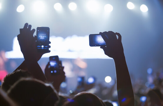 Concert crowd with mobile phones. Sea of hands filming the show with smartphones