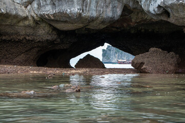 View through a rock arch on a limestone karst island in the Ha Long Bay UNESCO World Heritage site in Qiang Ninh Province in northern Vietnam