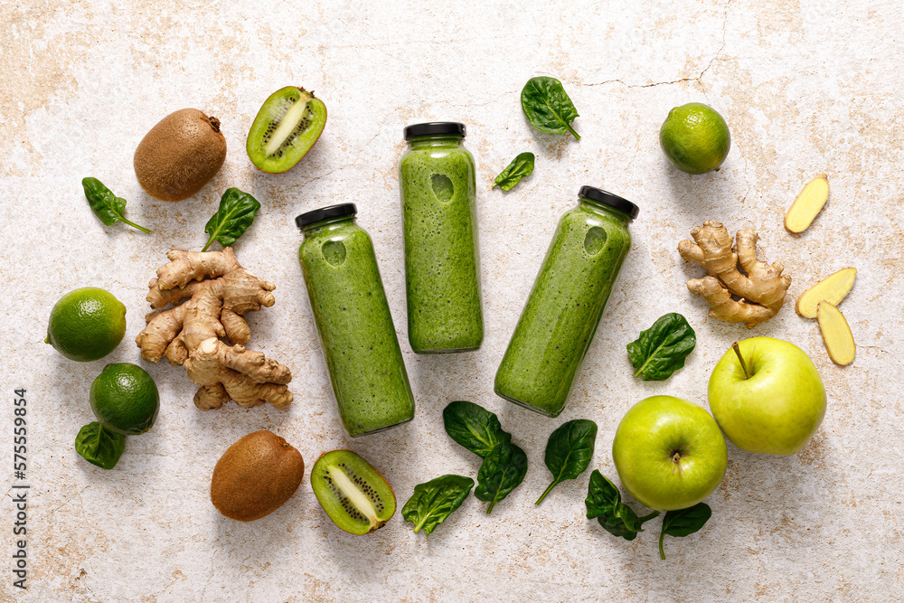 Wall mural Smoothie. Healthy fresh raw detox spinach smoothie with green apple, kiwi and ginger in a bottles on a table. Healthy diet vegan food full of antioxidants. Top view