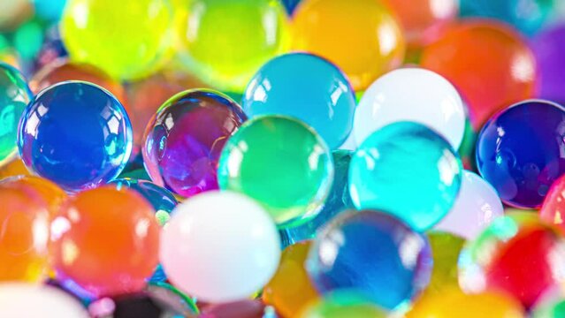 4K Time Lapse of Water beads growing in water close-up, abstract background. Texture of Hydrogel jelly balls - many colorful beads.