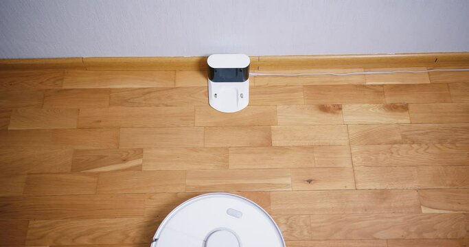 Robot vacuum cleaner performs automatic cleaning of the house at a certain time. Smart home concept. Copy space