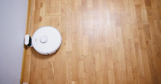 Robot vacuum cleaner performs automatic cleaning of the house at a certain time. Smart home concept. Copy space