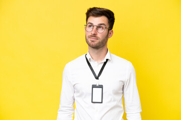 Young caucasian with ID card isolated on yellow background thinking an idea while looking up