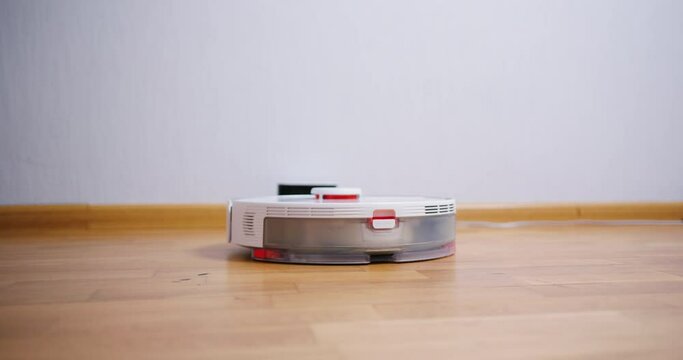 Robot vacuum cleaner performs automatic cleaning of the house at a certain time. Smart home concept. Copy space
