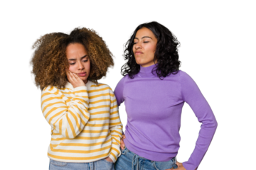 Two female friends isolated in studio touching back of head, thinking and making a choice.
