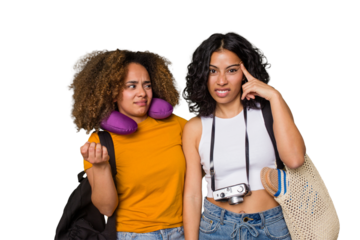 Two diverse friends on a beach vacation with vintage camera, beach bag, and travel pillow showing a disappointment gesture with forefinger.