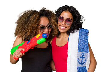 Fototapeta na wymiar Two women, one with Afro hair and the other Latina, are ready for a beach vacation in their swimwear.