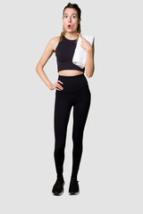 Fototapeta premium Full body of young woman in sportswear, fit and athletic, embodying a healthy and active lifestylepointing to the side
