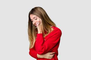 Young blonde posing for a portrait isolated, exuding natural beauty and radiance laughs happily and...