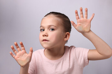 Cute little girl stuck to transparent screen