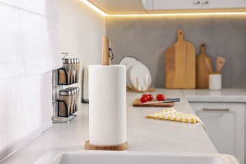 Obraz na płótnie Canvas Roll of paper towels on white countertop in kitchen, space for text