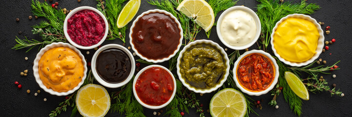 Different types of sauces in bowls with seasonings banner, rosemary and dill, thyme and and peppercorns, top view, copy space