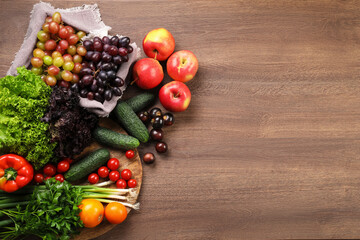 Fototapeta na wymiar Different fresh ripe vegetables and fruits on wooden table, flat lay. Space for text