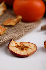 A pattern of a pile of dried apples, sliced, on a white concrete or slate background. Dried fruit chips. Healthy food. Top view