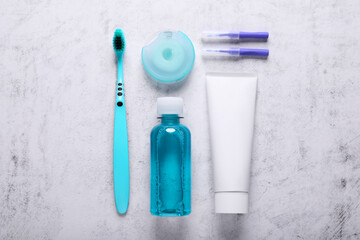 Flat lay composition with dental floss and different teeth care products on light grey textured...