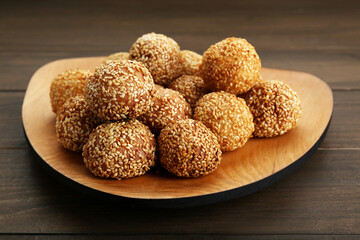 Many delicious sesame balls on wooden table, closeup