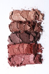 Different crushed eye shadows on white background, top view. Professional makeup product