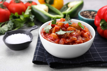 Delicious lecho with parsley in bowl on table, closeup