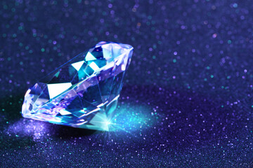 Beautiful diamond on shiny blue background, closeup. Space for text